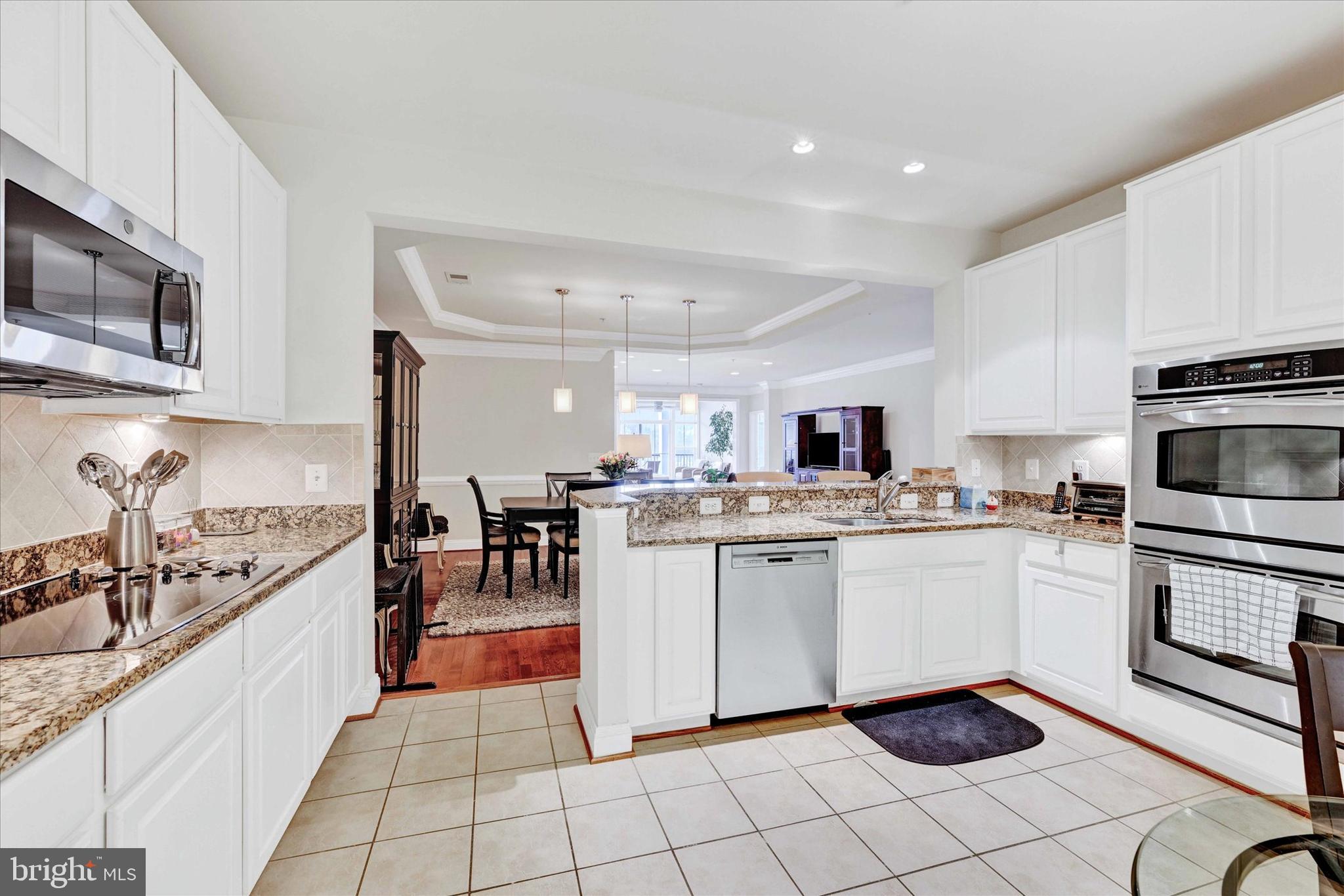 3000 Stone Cliff Drive, Unit 205 Baltimore, MD 21209 - Photo 13 of 28 a kitchen with stainless steel appliances granite countertop a sink and cabinets
