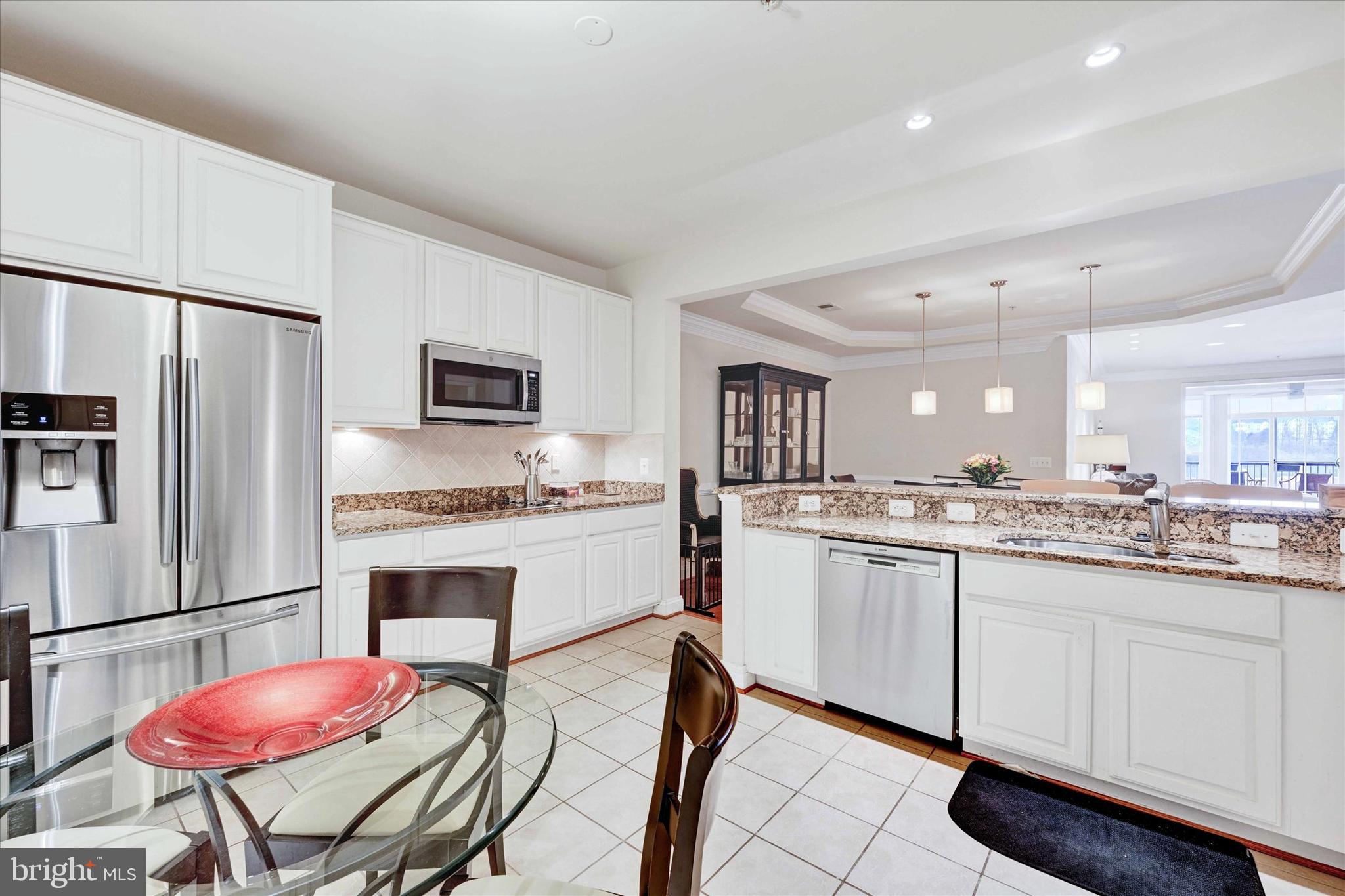 3000 Stone Cliff Drive, Unit 205 Baltimore, MD 21209 - Photo 14 of 28 a kitchen with granite countertop a sink stove and refrigerator