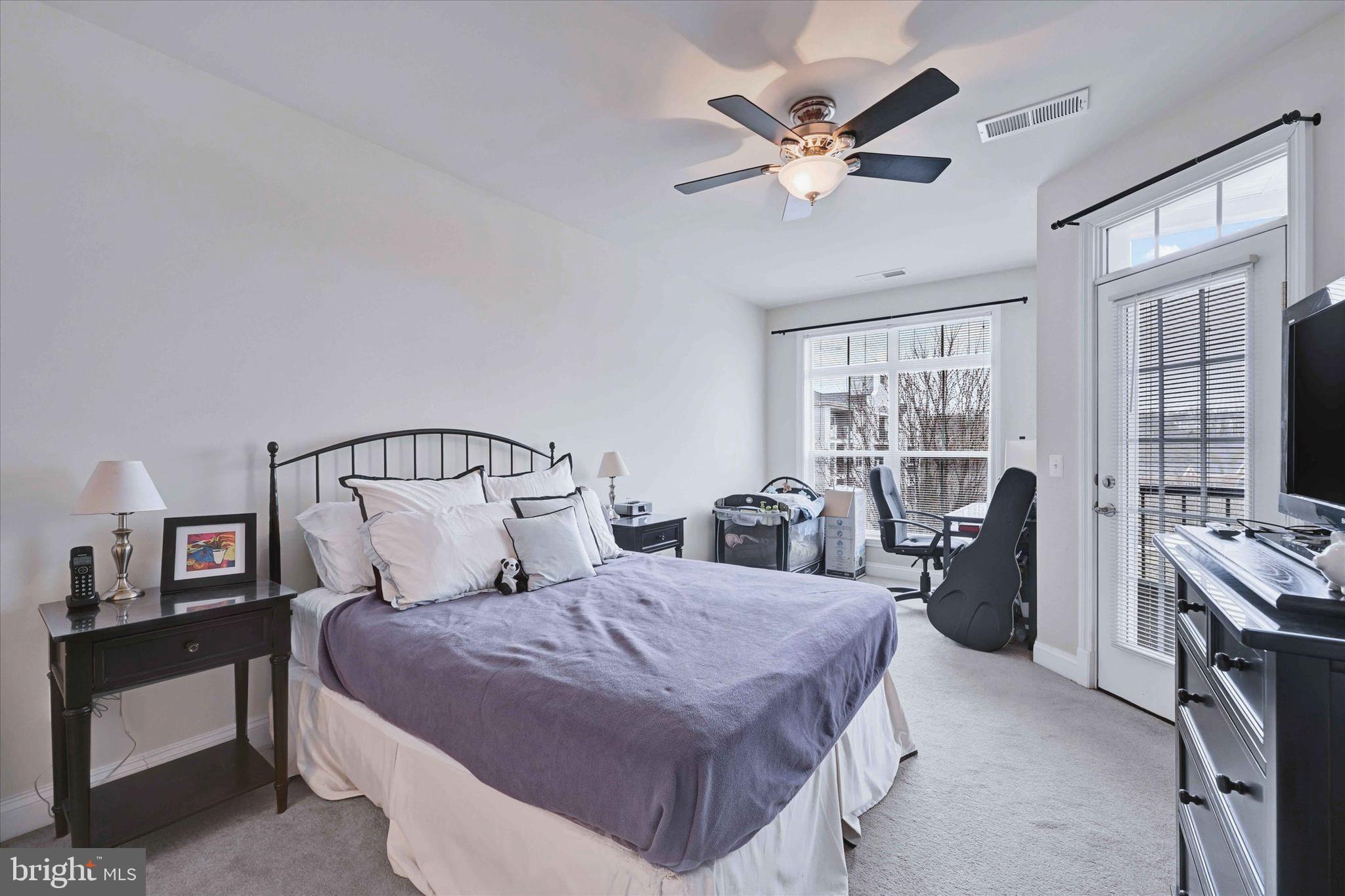 3000 Stone Cliff Drive, Unit 205 Baltimore, MD 21209 - Photo 20 of 28 a bedroom with a bed a large window and furniture