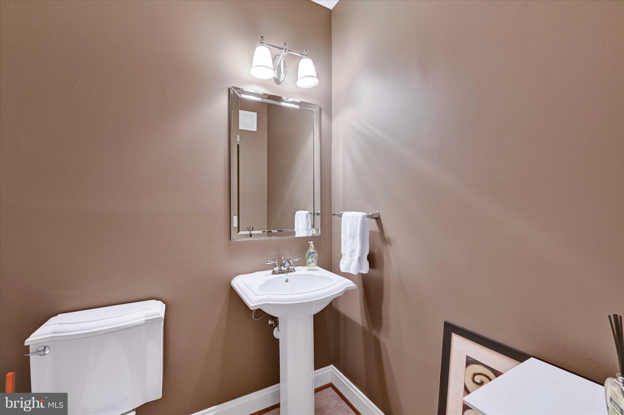 3000 Stone Cliff Drive, Unit 205 Baltimore, MD 21209 - Photo 24 of 28 a bathroom with a toilet sink and mirror