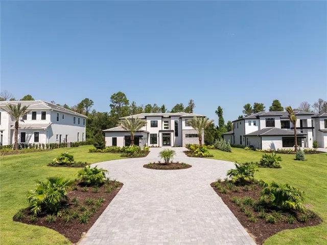a front view of a house with a garden and trees