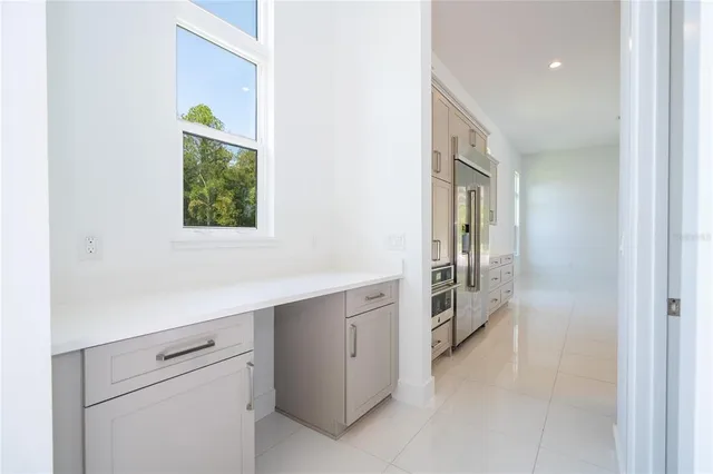 a large white kitchen with a refrigerator a sink and a stove top oven