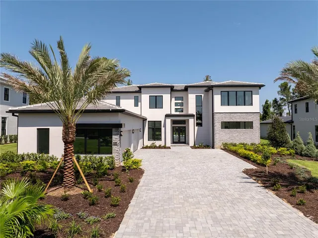 a front view of a house with plants and trees