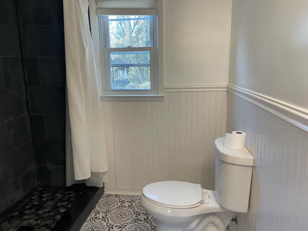 a white toilet sitting next to a window