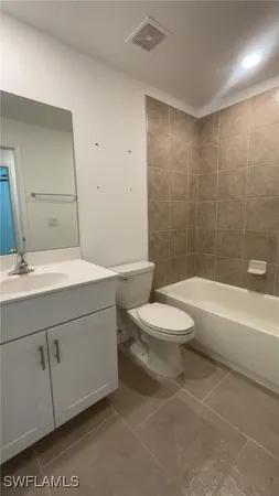 a white toilet sitting next to a bath tub and a shower