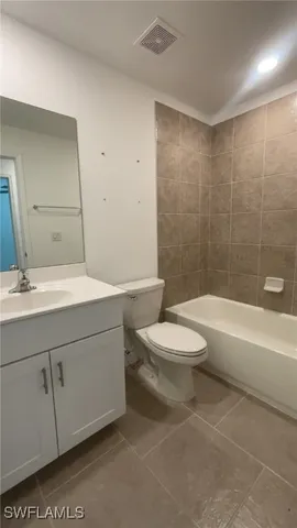 a white toilet sitting next to a bath tub and a shower