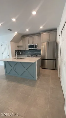 a kitchen with stainless steel appliances granite countertop a refrigerator and a stove top oven
