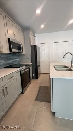 a kitchen with stainless steel appliances granite countertop a refrigerator sink and stove