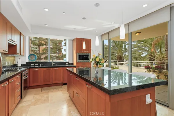 a kitchen with granite countertop a sink stainless steel appliances and cabinets