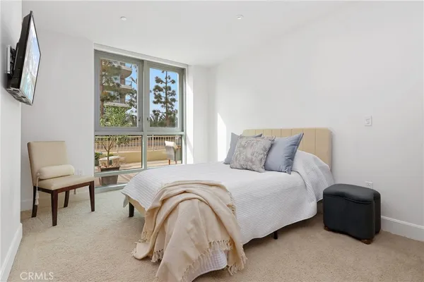 a large bed sitting in a bedroom next to a window