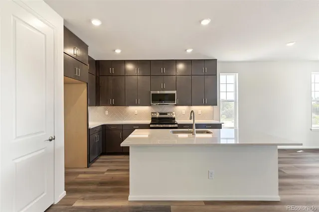 a kitchen with kitchen island a sink stainless steel appliances and cabinets