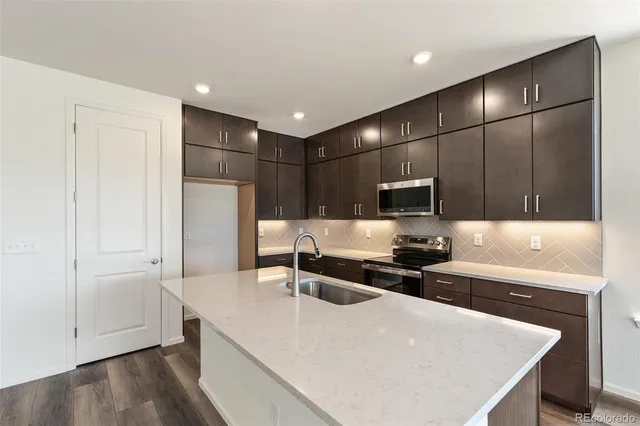 a kitchen with stainless steel appliances a microwave a sink and a refrigerator