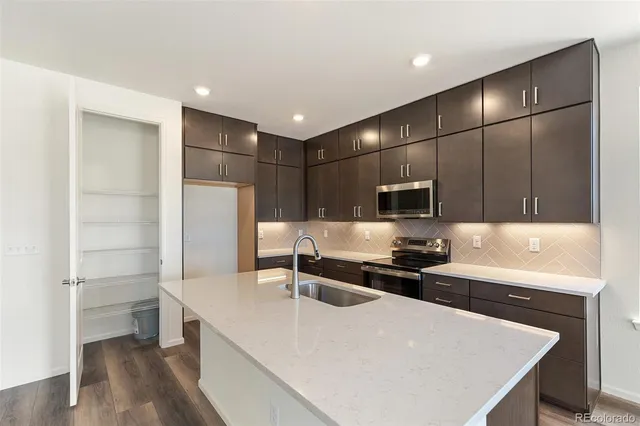 a kitchen with stainless steel appliances a refrigerator and a stove top oven