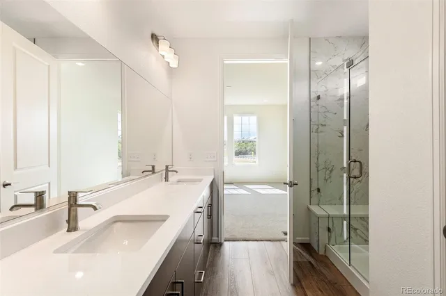 a en suite bathroom with a double vanity sink a mirror and a shower