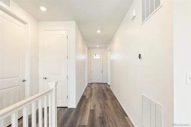 a view of a hallway with wooden floor