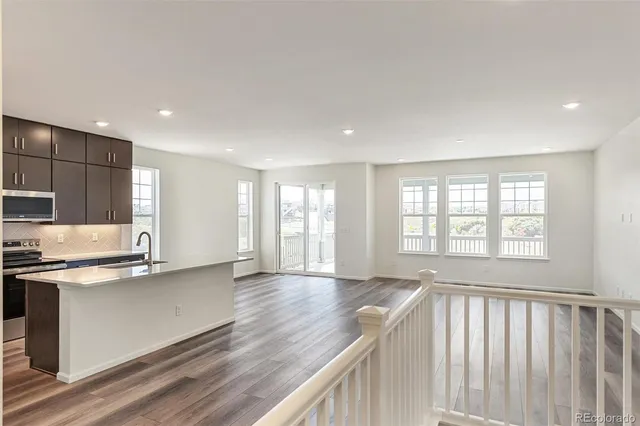 a view of a kitchen with a sink and dishwasher wooden cabinets with wooden floor