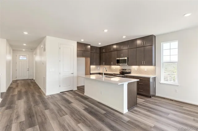 a kitchen with stainless steel appliances granite countertop a sink stove and refrigerator