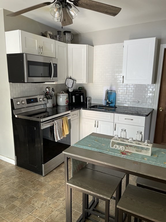 23 Preston Street Springfield, MA 01109 - Photo 8 of 24 a kitchen with stainless steel appliances a stove a microwave a sink and cabinets