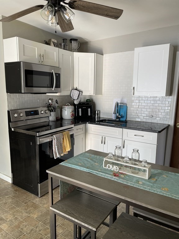 23 Preston Street Springfield, MA 01109 - Photo 9 of 24 a kitchen with kitchen island granite countertop a sink appliances and cabinets