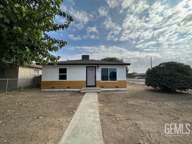 a view of a house with a yard and large tree