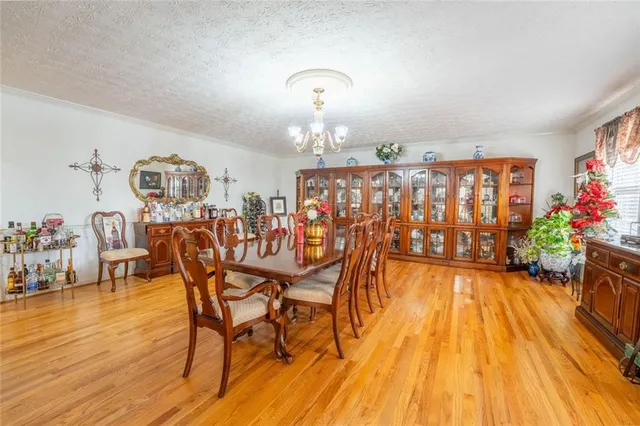 a kitchen with stainless steel appliances a stove a sink and white cabinets with wooden floor