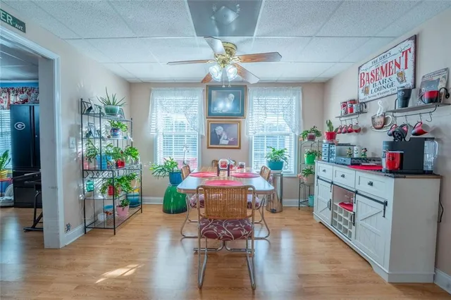a view of house with a yard and a large parking space