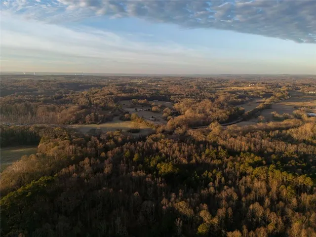 a view of a large house with a big yard and large tree