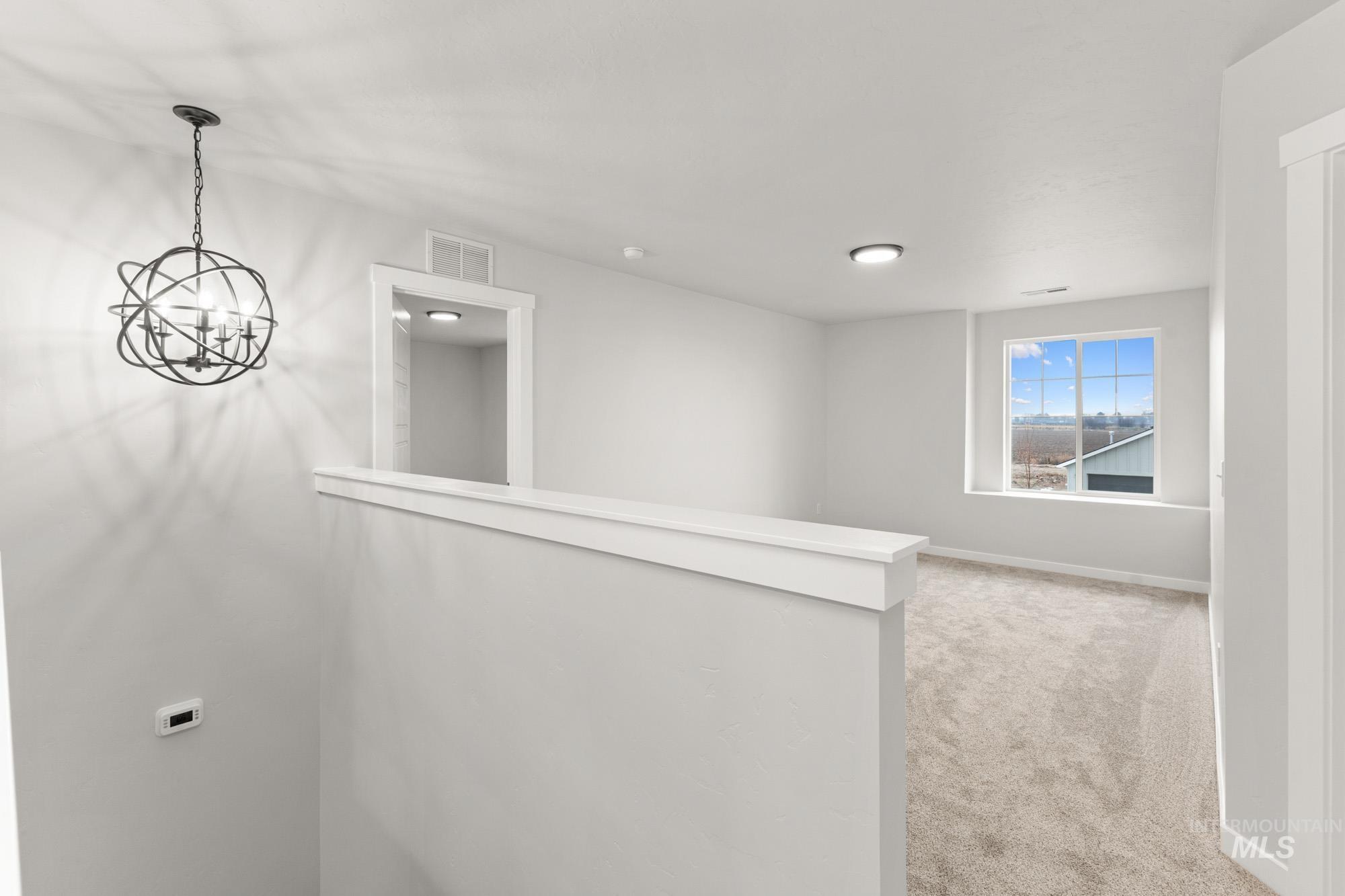 3762 West Maypearl Street Meridian, ID 83642 - Photo 13 of 29 Corridor with light carpet and a chandelier