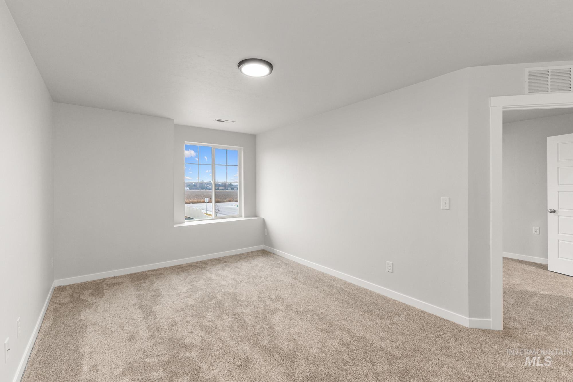 3762 West Maypearl Street Meridian, ID 83642 - Photo 14 of 29 Empty room featuring light carpet and baseboards