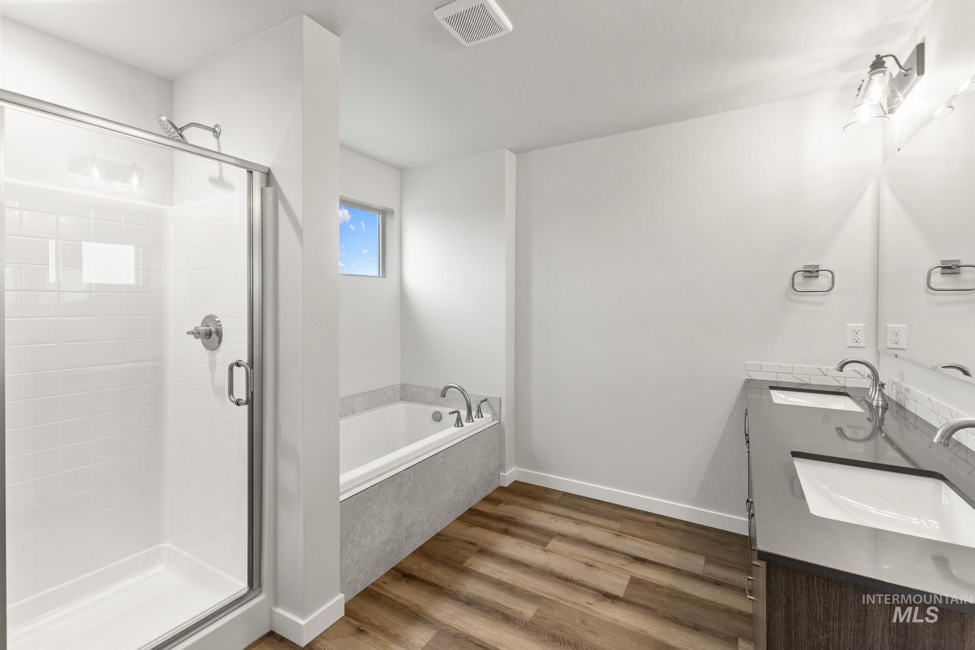 3762 West Maypearl Street Meridian, ID 83642 - Photo 24 of 29 Bathroom featuring double vanity, light wood-type flooring, a stall shower, and a bath