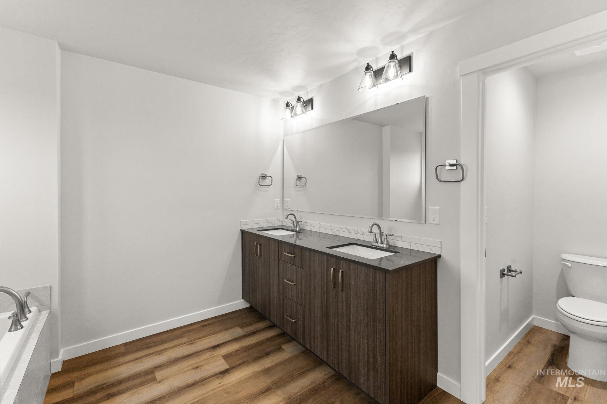3762 West Maypearl Street Meridian, ID 83642 - Photo 25 of 29 Full bath featuring double vanity, dark wood-style floors, and a tub to relax in