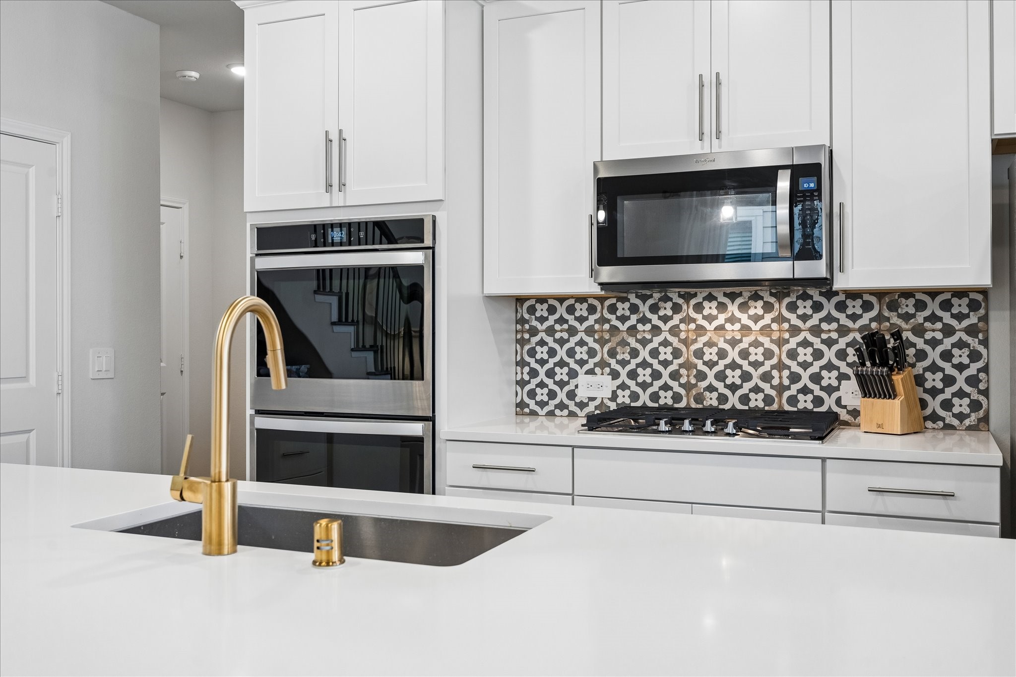 4026 Delta Rose Street Houston, TX 77018 - Photo 15 of 44 Kitchen detail featuring quartz counters, statement tile backsplash and upgraded faucet and modern fixtures.