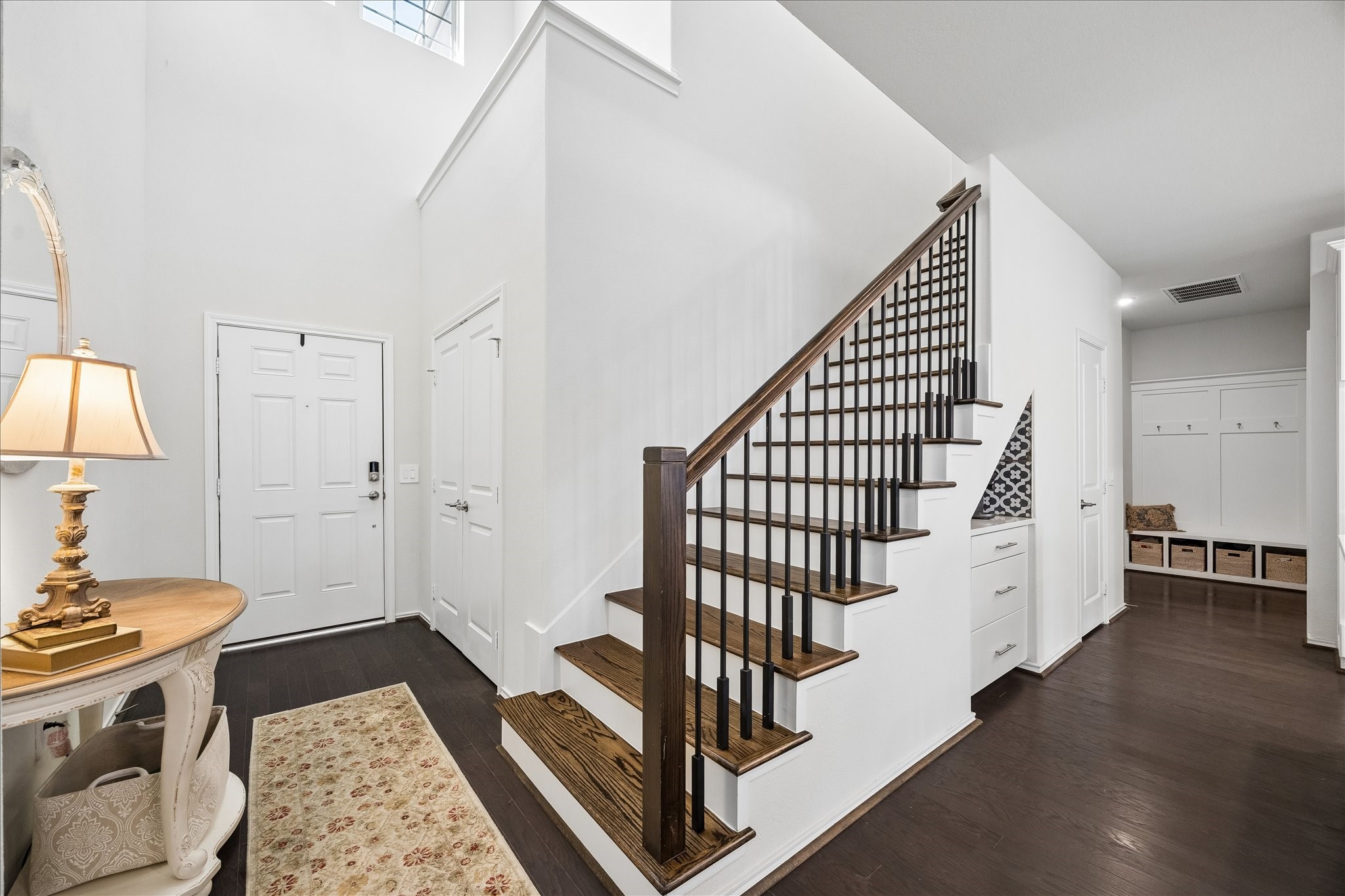 4026 Delta Rose Street Houston, TX 77018 - Photo 3 of 44 Spacious entry with high ceilings, a staircase featuring wood treads and iron balusters and a functional mud area with built in storage and bench seating.