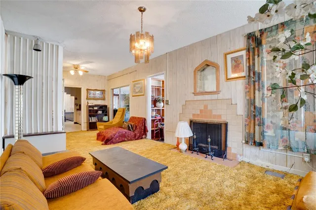 a living room with furniture a fireplace and a chandelier
