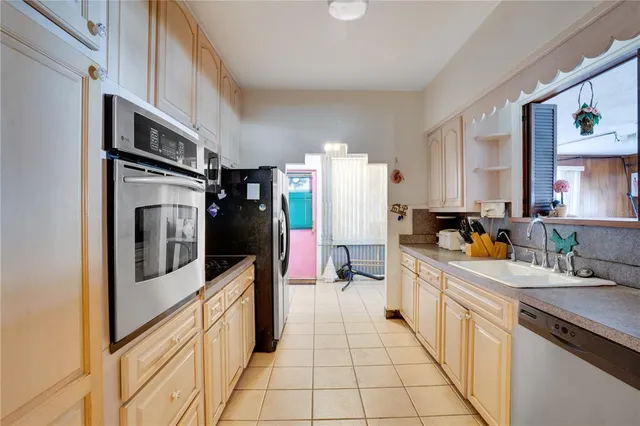 a kitchen with stainless steel appliances a refrigerator sink and cabinets