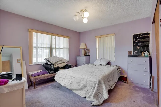 a spacious bedroom with two beds and a window