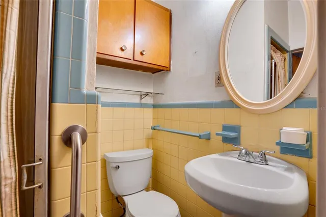 a bathroom with a toilet sink and mirror