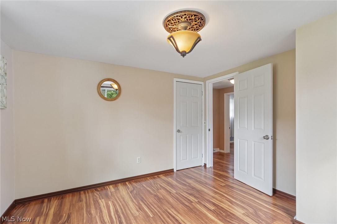 4188 Manchester Road Perry, OH 44081 - Photo 24 of 41 Wood-finish flooring, neutral wall tones, two paneled doors, and a ceiling-mounted light fixture with decorative trim