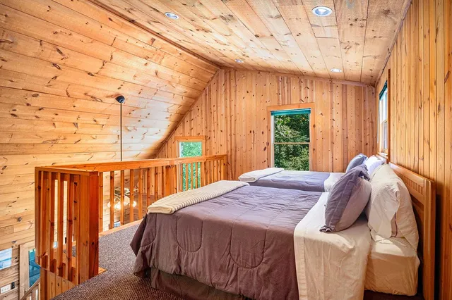 a bed sitting in a bedroom next to a window