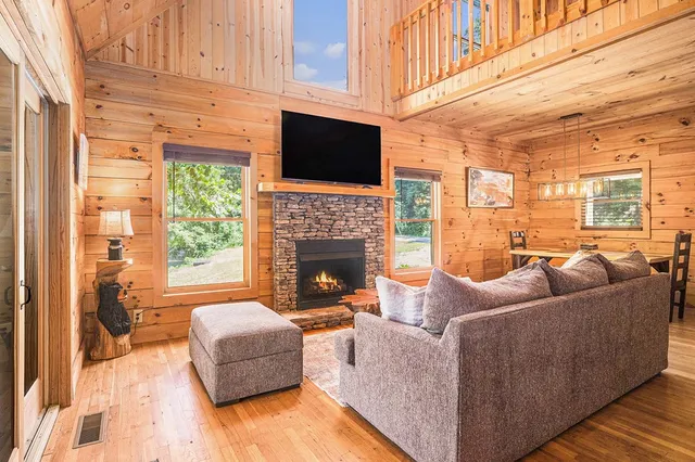 a living room with furniture a fireplace and a flat screen tv