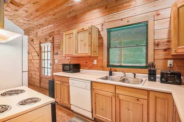 a kitchen with a sink a stove a refrigerator and cabinets