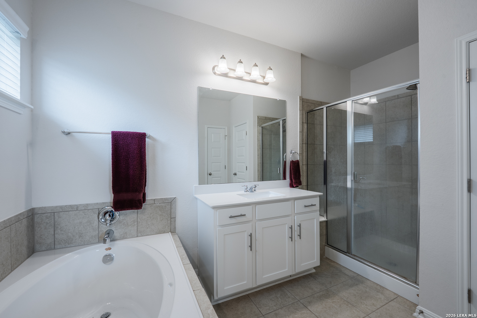 4947 Ranahan Pass St. Hedwig, TX 78152 - Photo 19 of 37 a bathroom with a sink a large mirror and a shower