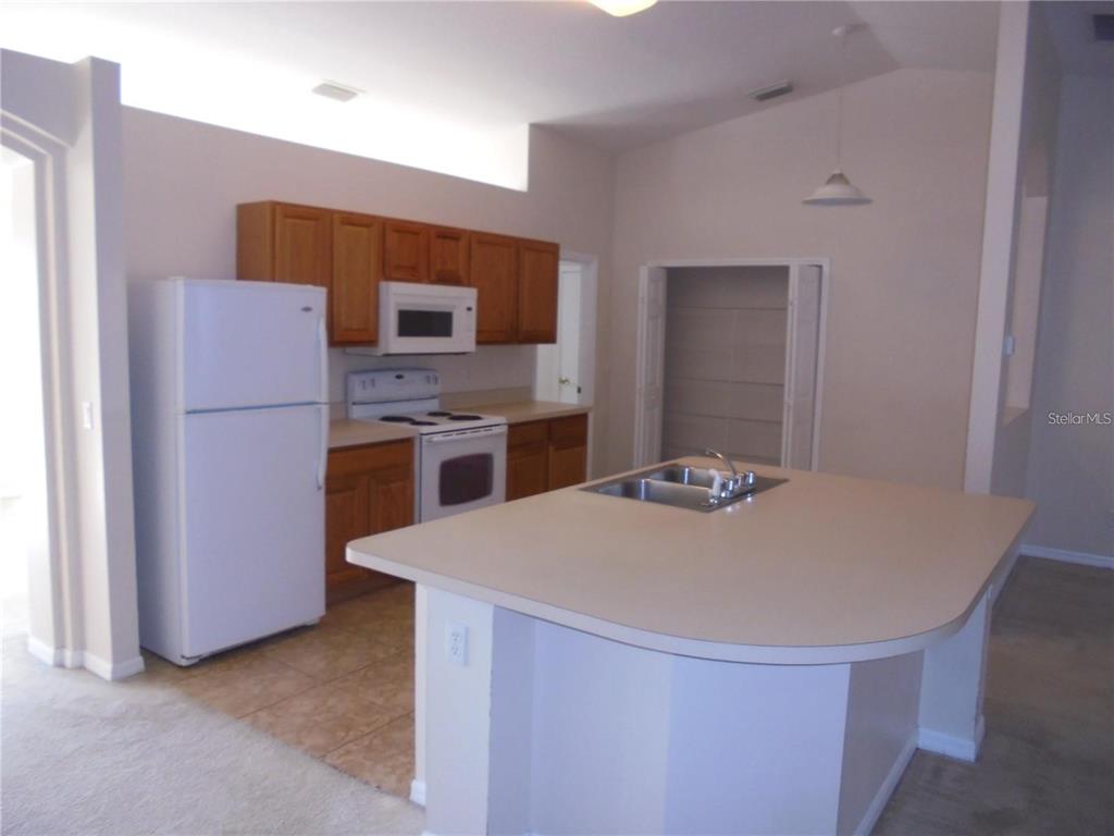4725 Southwest 100th Street Ocala, FL 34476 - Photo 9 of 24 a kitchen with stainless steel appliances a refrigerator and a stove