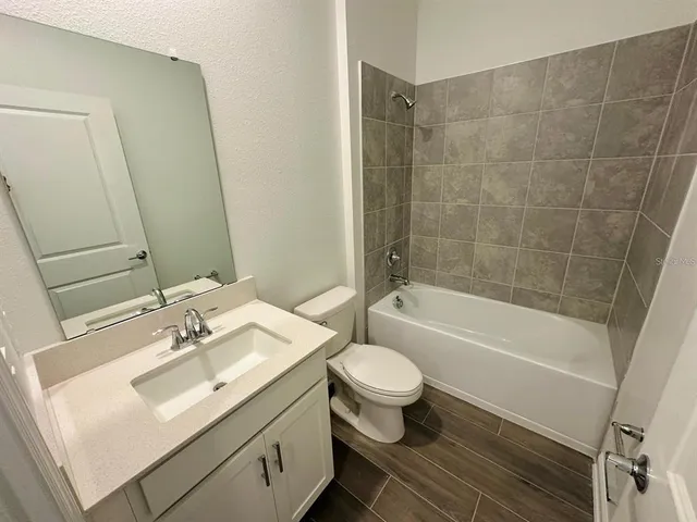 a bathroom with a sink toilet a mirror and shower