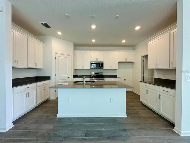 a large kitchen with stainless steel appliances granite countertop a stove a sink dishwasher and a refrigerator