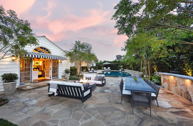 an outdoor sitting area with couch and wooden fence