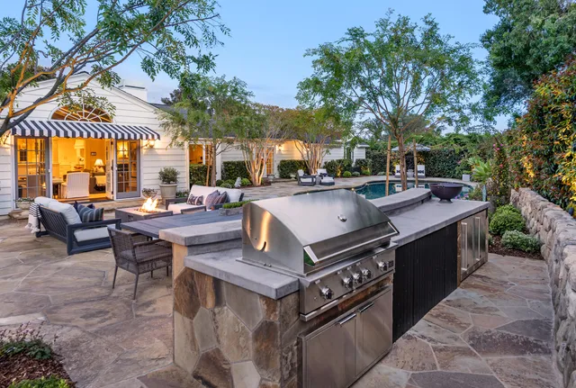 a view of a patio with table and chairs and a barbeque