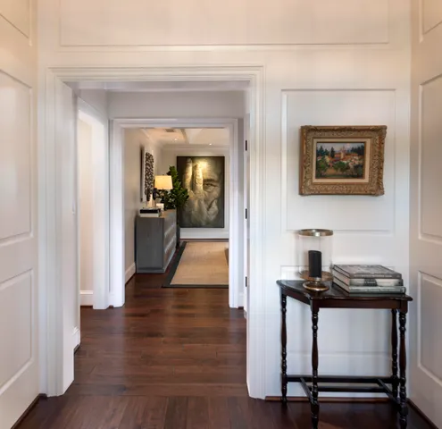 a view of a hallway with wooden floor and furniture