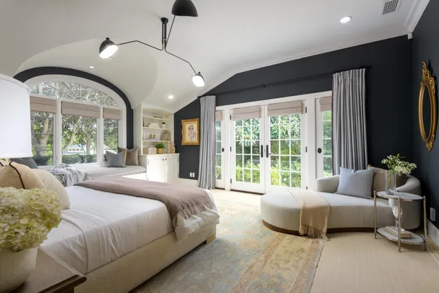 a spacious bedroom with a bed and large windows