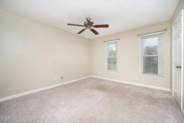 a view of empty room with wooden floor and chandelier